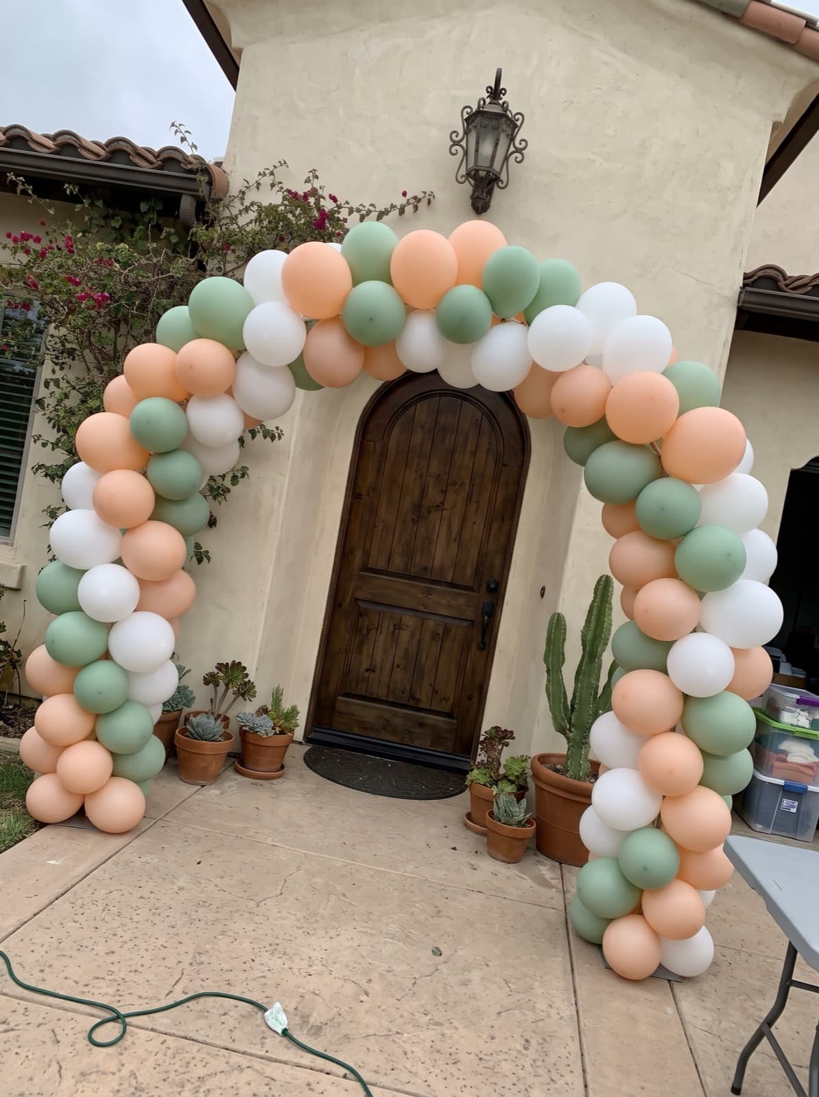 Balloon arch over the front door of a Spanish-style stucco home