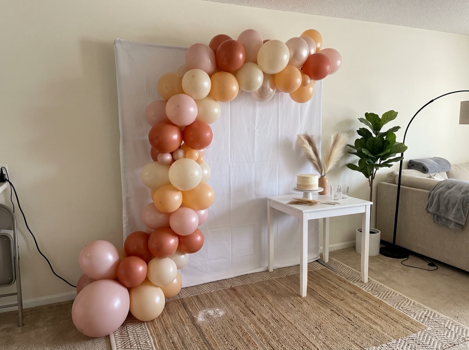 Blush, rust and cream half arch swooping over a cake table