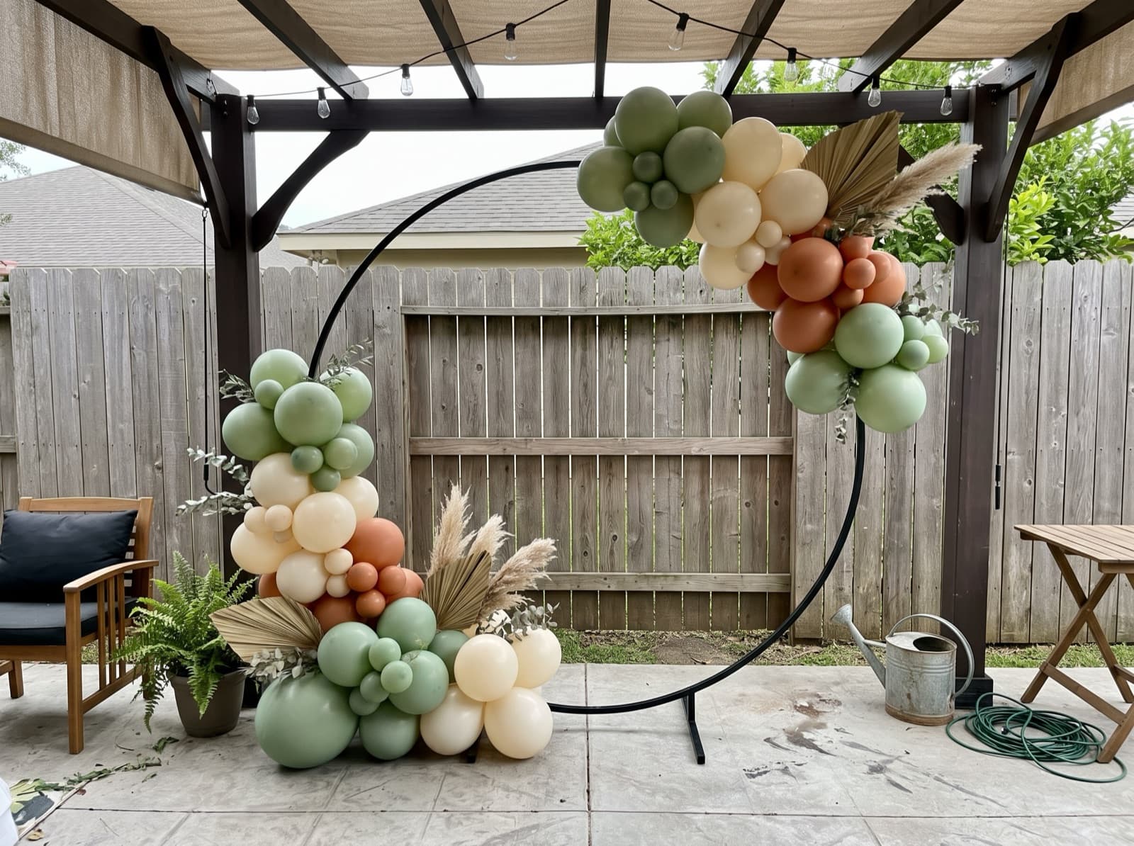 Round balloon arch with dried palm accents framing a patio photo spot